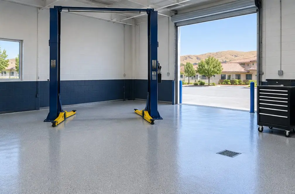 Illustration: a four-bay auto repair shop with a light-gray quartz epoxy floor, two-post lifts and painted bay boundary lines