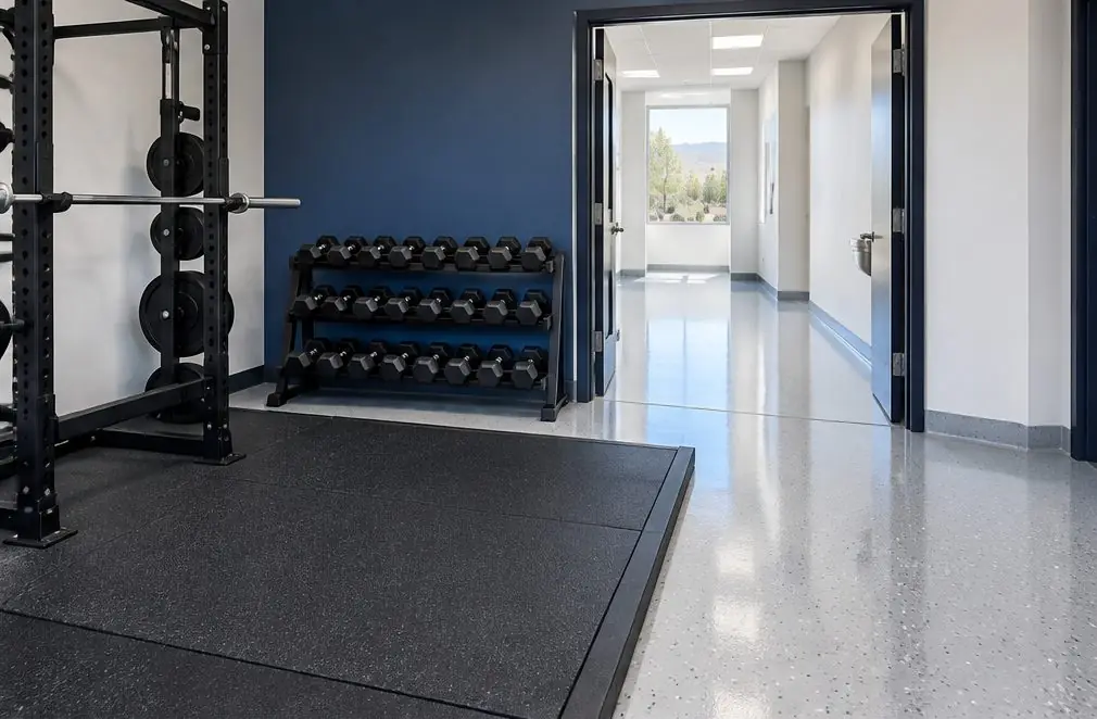 Illustration: a fitness studio with a rubber lifting platform beside a bright flake-coated locker room corridor and a coved wet-area edge